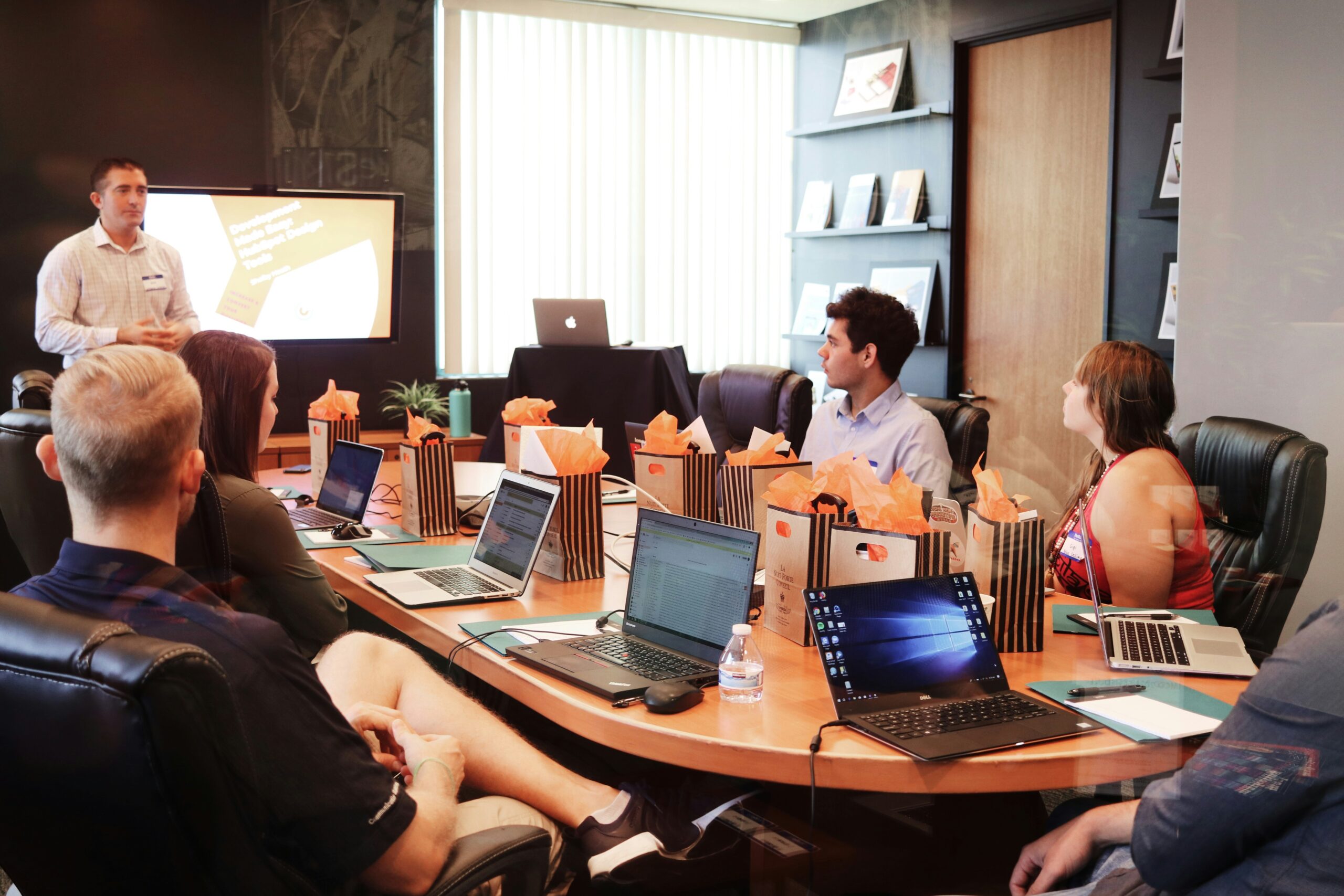 Several people engaged in discussion at a table, utilizing laptops to share ideas and collaborate effectively.