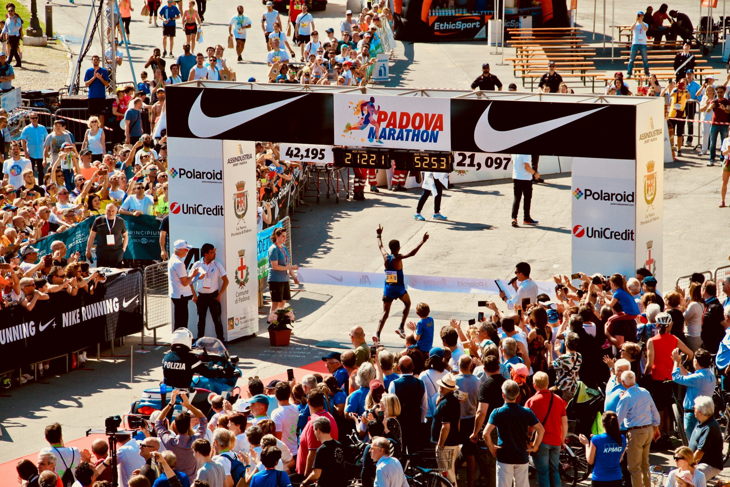 Enthusiastic spectators gather at the marathon finish line, cheering for the runners as they complete the race.